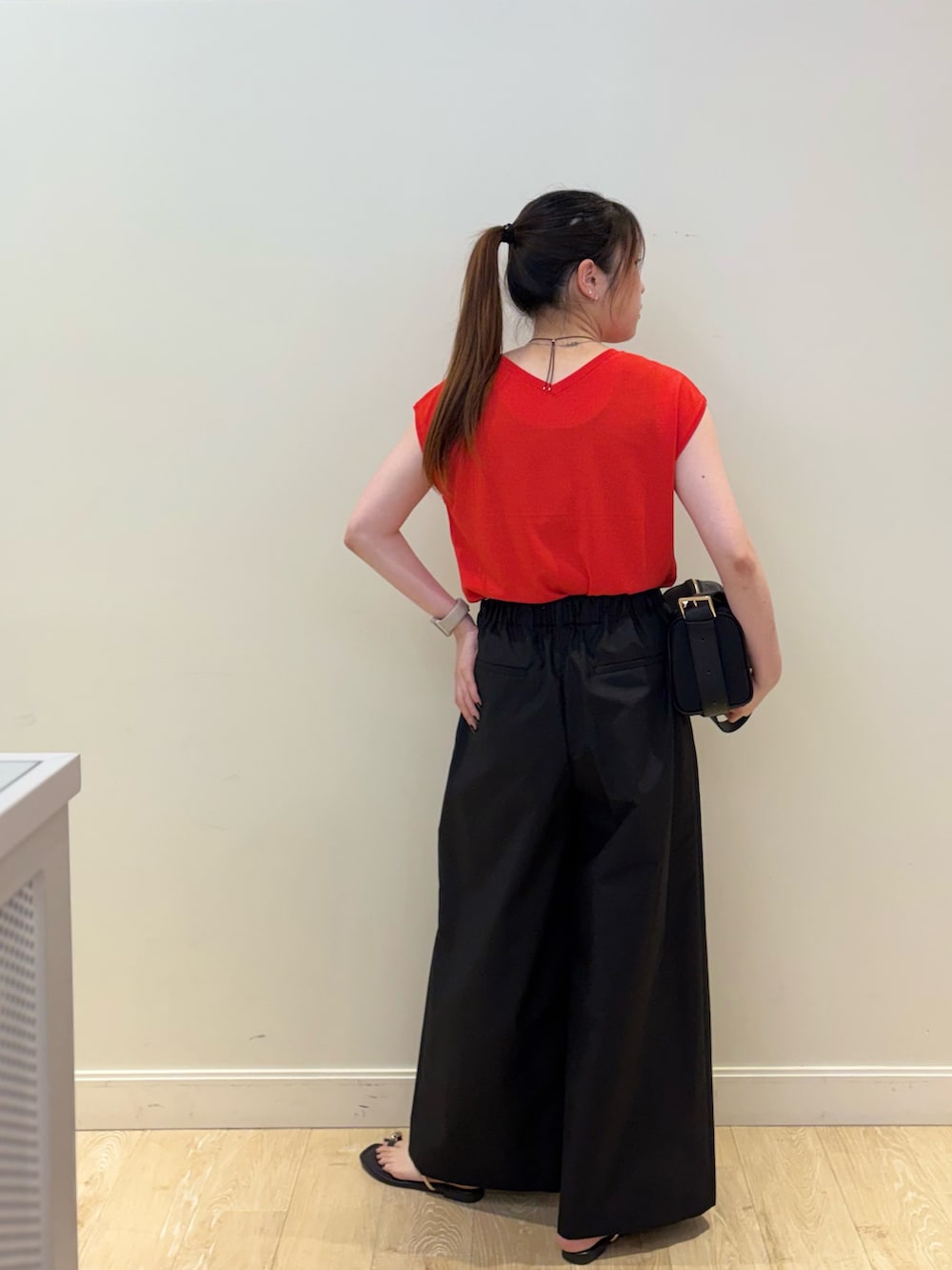 ブラック系のその他パンツ、ブラック系のショルダーバッグ、レッド系のニット/セーターを着用したレディースの夏コーディネートの4枚目の写真
