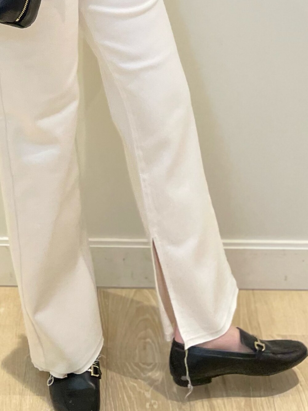 ホワイト系のデニムパンツ、ブラック系のベスト、シルバー系のTシャツ/カットソーを着用したレディースの冬コーディネートの3枚目の写真