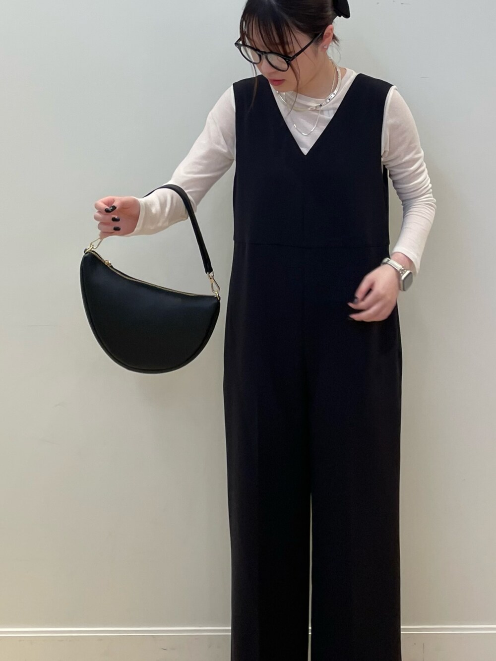 ブラック系のサロペット/オーバーオール、ブラック系のショルダーバッグ、ホワイト系のTシャツ/カットソーを着用したレディースの冬コーディネートの4枚目の写真