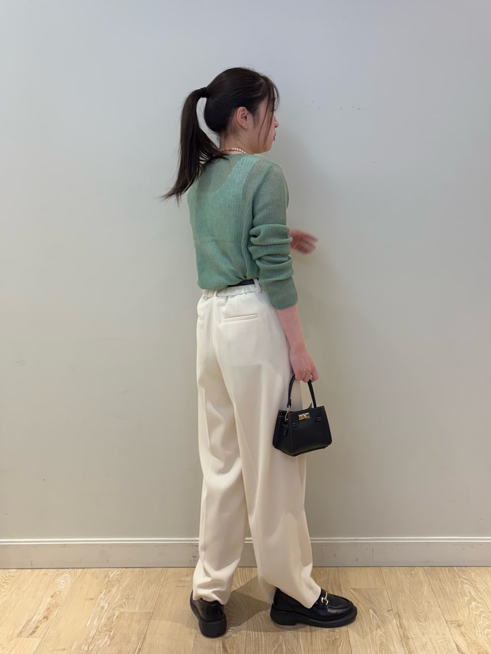 ブラック系のショルダーバッグ、ホワイト系のその他パンツ、ホワイト系のタンクトップを着用したレディースの冬コーディネートの3枚目の写真