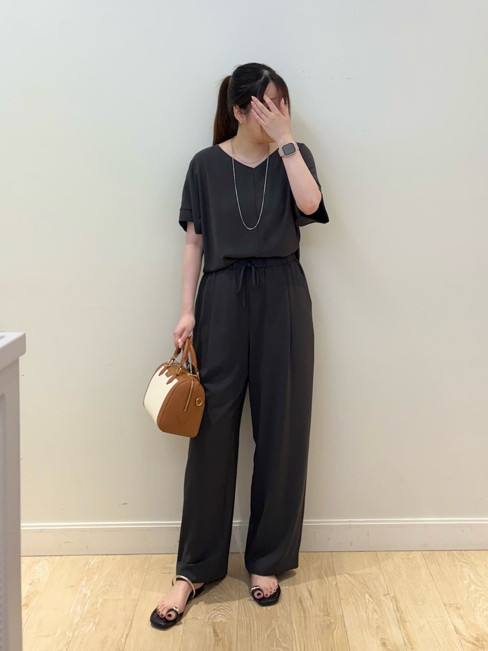 ブラウン系のボストンバッグ、グレー系のその他パンツ、グレー系のシャツ/ブラウスを着用したレディースの夏コーディネートの4枚目の写真