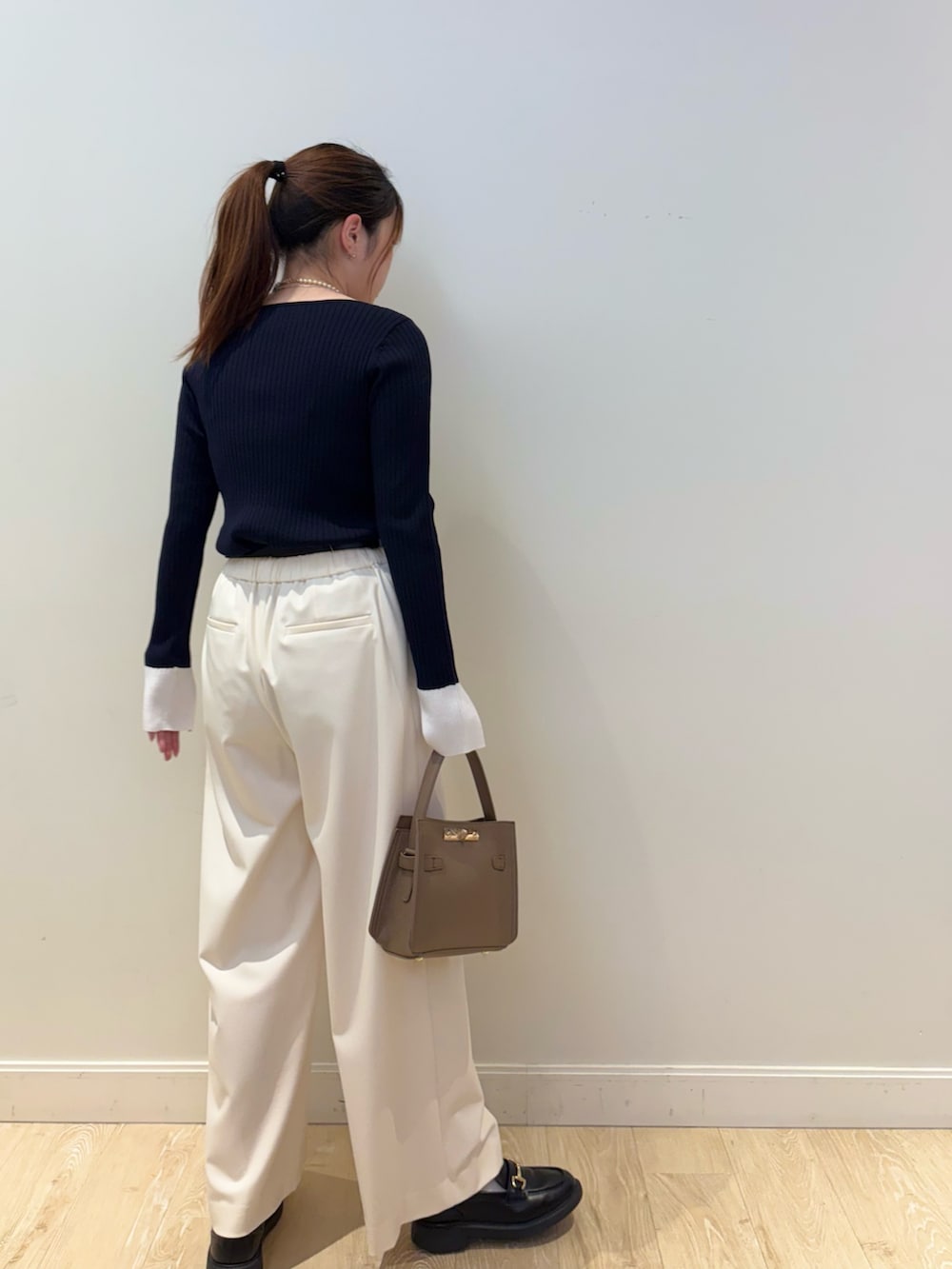 ベージュ系のショルダーバッグ、ホワイト系のその他パンツ、ブルー系のニット/セーターを着用したレディースの冬コーディネートの3枚目の写真