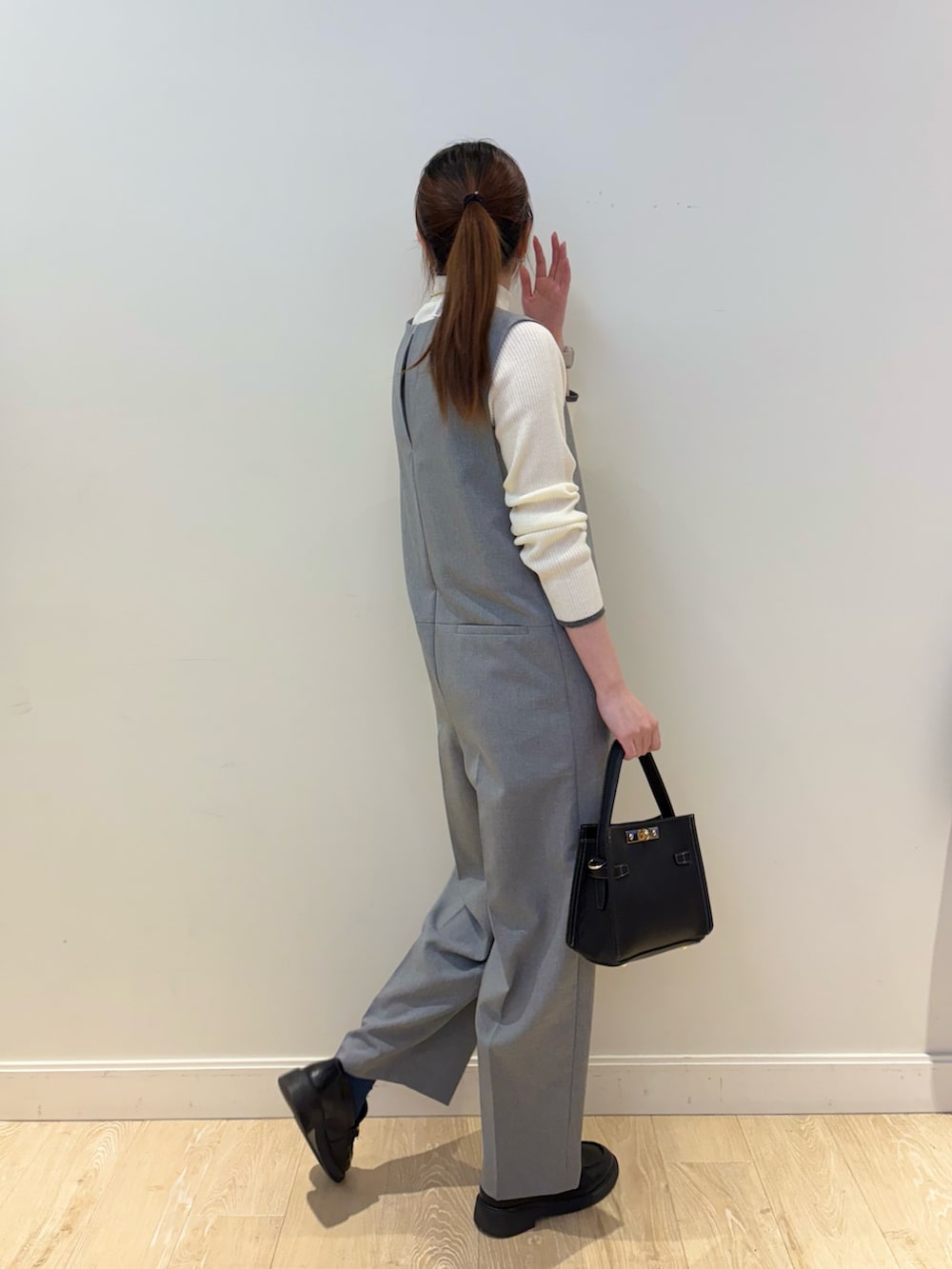 ブラック系のショルダーバッグ、ホワイト系のその他トップス、グレー系のつなぎ/オールインワンを着用したレディースの冬コーディネートの3枚目の写真