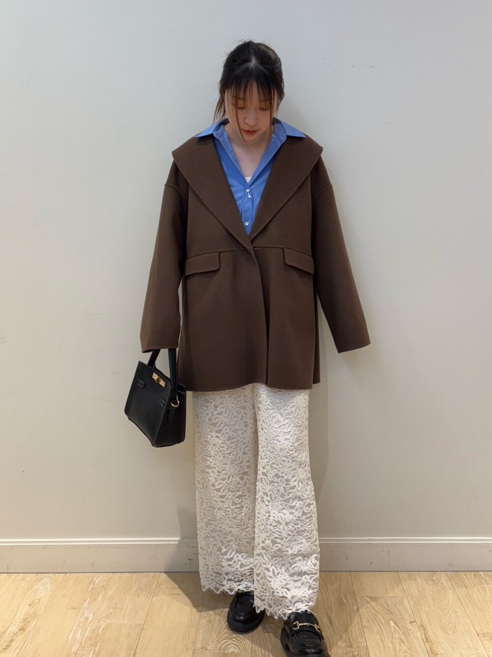 ブラック系のショルダーバッグ、ブラウン系のその他アウター、ブルー系のシャツ/ブラウスを着用したレディースの冬コーディネートの4枚目の写真