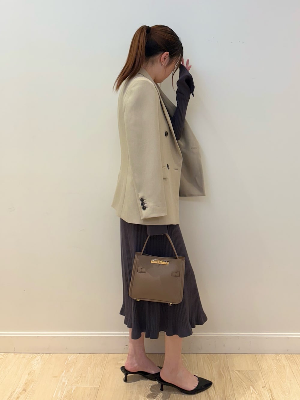ベージュ系のショルダーバッグ、グレー系のワンピース、ベージュ系のテーラードジャケットを着用したレディースの冬コーディネートの2枚目の写真