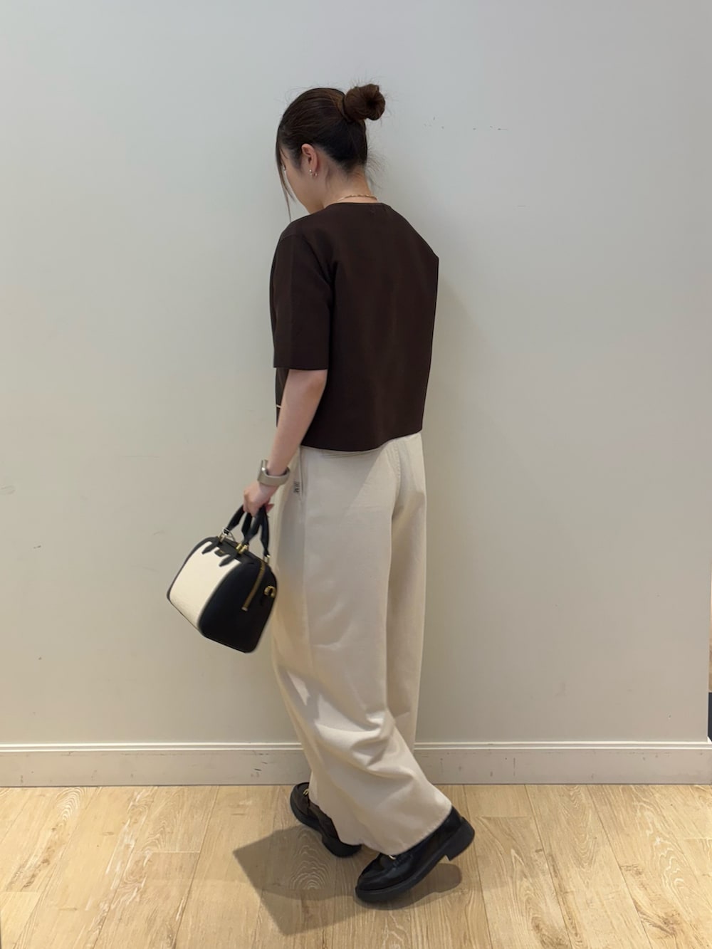 ブラック系のボストンバッグ、ブラウン系のニット/セーター、ホワイト系のその他パンツを着用したレディースの春コーディネートの3枚目の写真