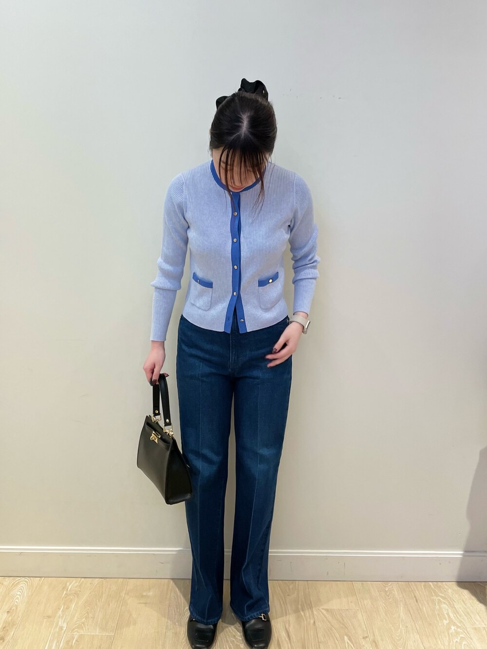 ブルー系のデニムパンツ、ブルー系のカーディガン/ボレロ、ブラック系のショルダーバッグを着用したレディースの冬コーディネートの3枚目の写真