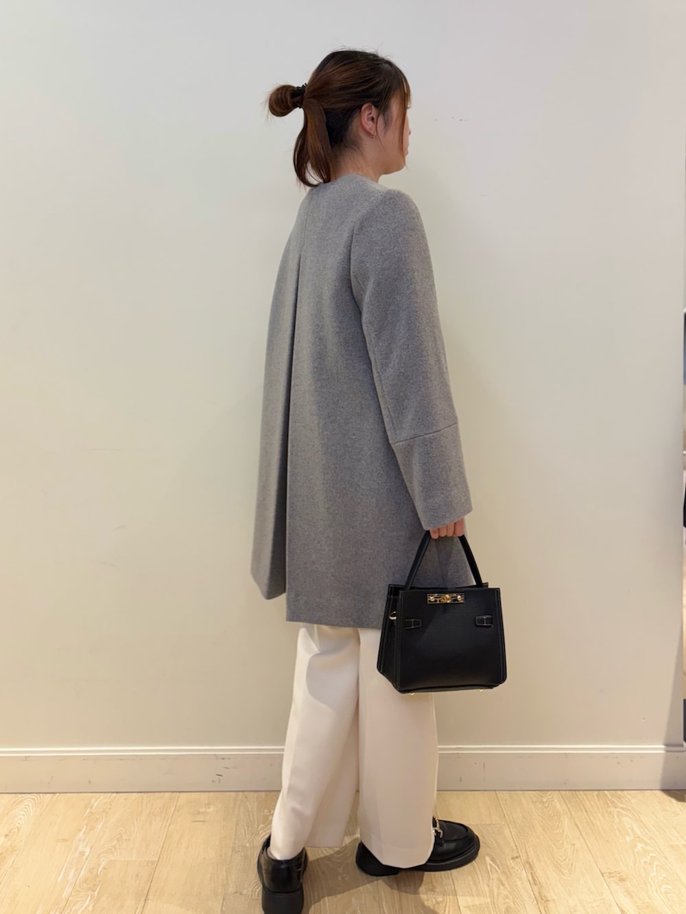 ブラック系のショルダーバッグ、ベージュ系のニット/セーター、ホワイト系のその他パンツを着用したレディースの冬コーディネートの3枚目の写真