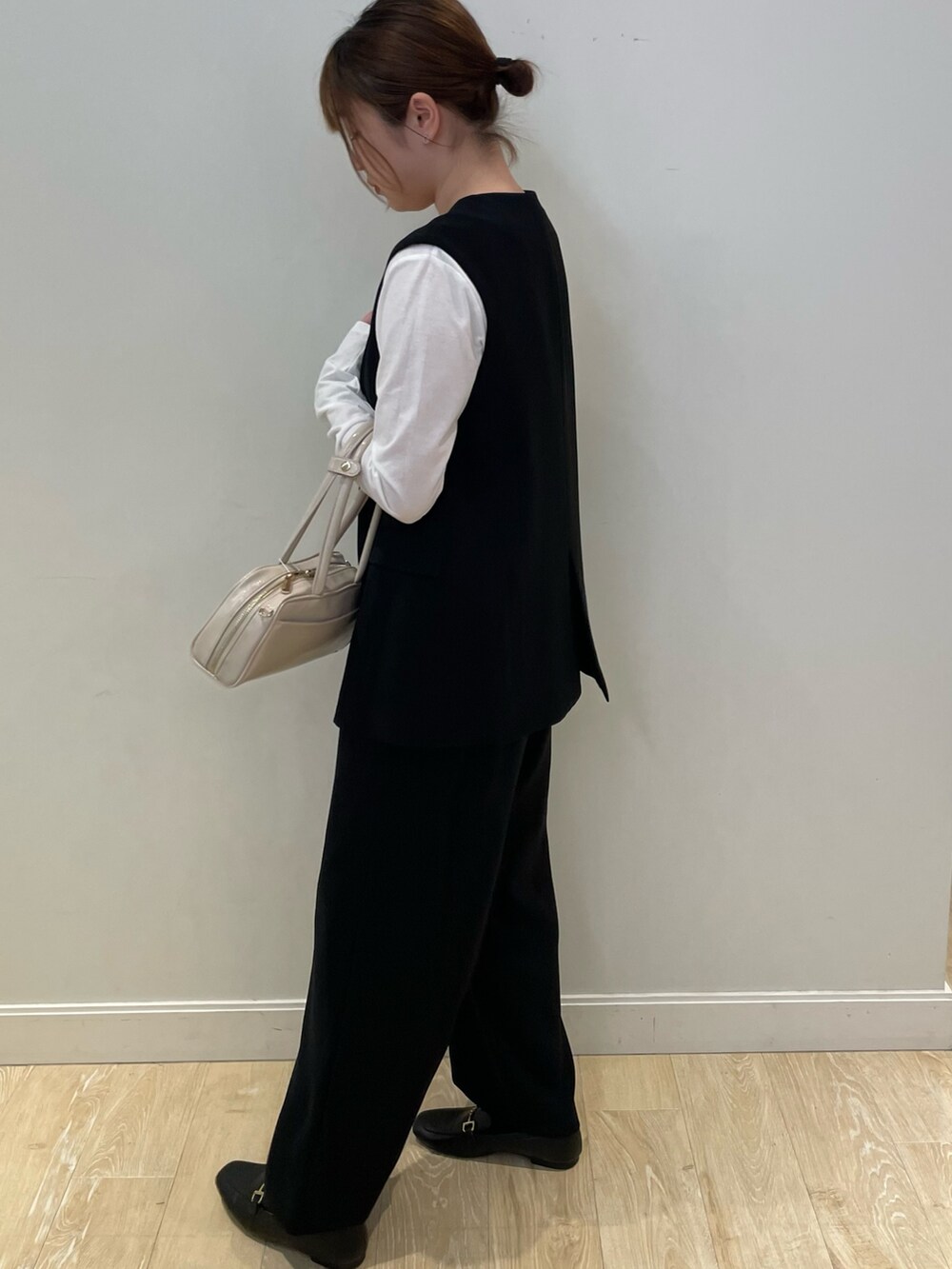 ブラック系のその他パンツ、ホワイト系のTシャツ/カットソー、ブラック系のベストを着用したレディースの秋コーディネートの4枚目の写真