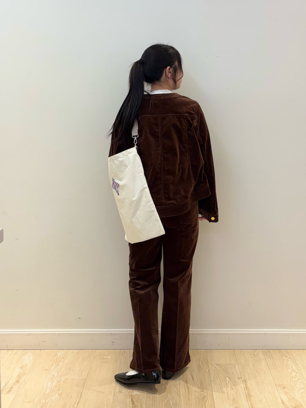 ブラウン系のブルゾン、ホワイト系のTシャツ/カットソー、ホワイト系のエコバッグ/サブバッグを着用したレディースの夏コーディネートの3枚目の写真