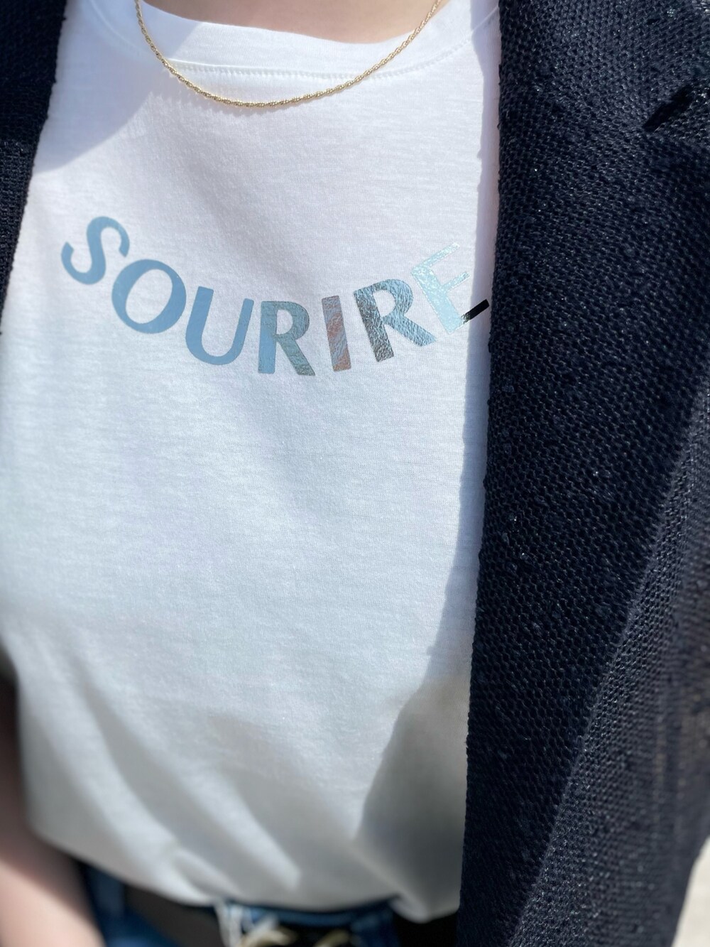 ホワイト系のTシャツ/カットソー、ブラック系のボストンバッグ、ブルー系のデニムパンツを着用したレディースの春コーディネートの7枚目の写真