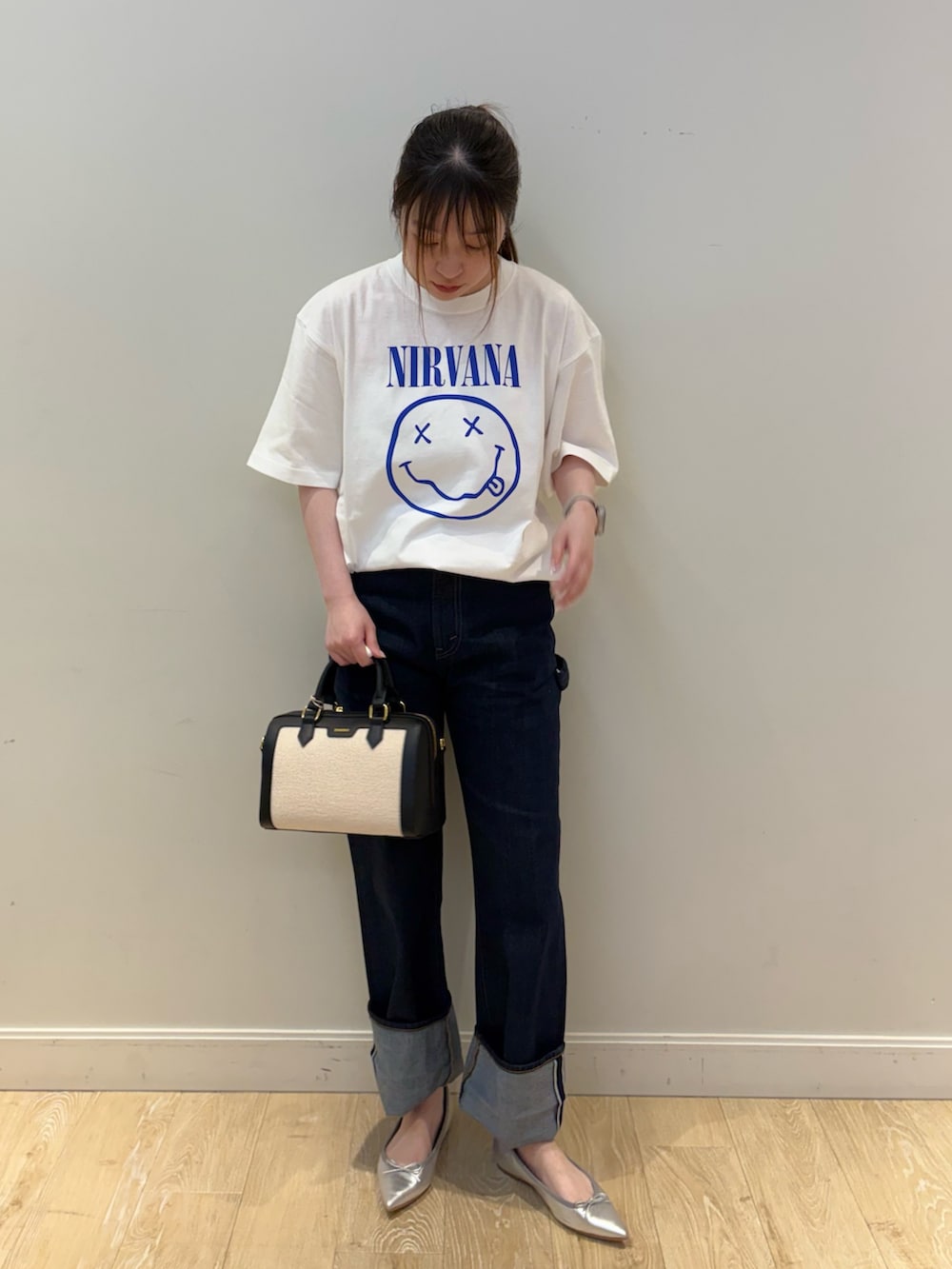 ブルー系のデニムパンツ、ブラック系のボストンバッグ、ホワイト系のTシャツ/カットソーを着用したレディースの春コーディネートの4枚目の写真