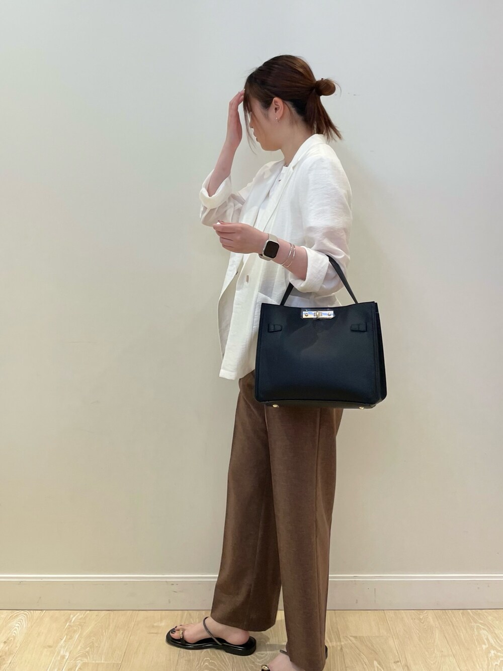 ブラック系のショルダーバッグ、グレー系のTシャツ/カットソー、ホワイト系のテーラードジャケットを着用したレディースの夏コーディネートの2枚目の写真