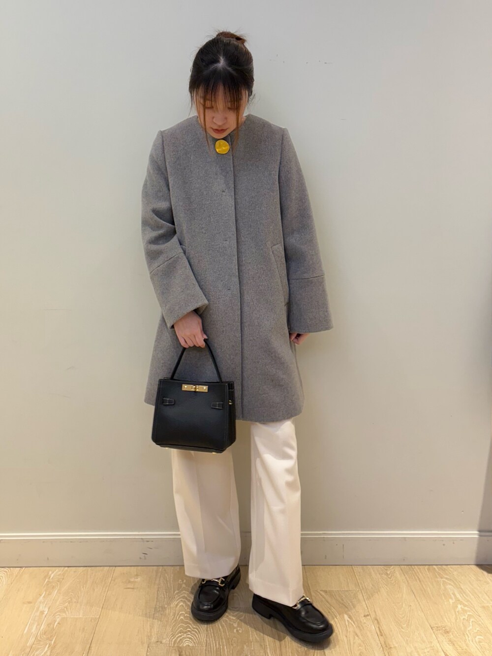 ブラック系のショルダーバッグ、ベージュ系のニット/セーター、ホワイト系のその他パンツを着用したレディースの冬コーディネートの4枚目の写真