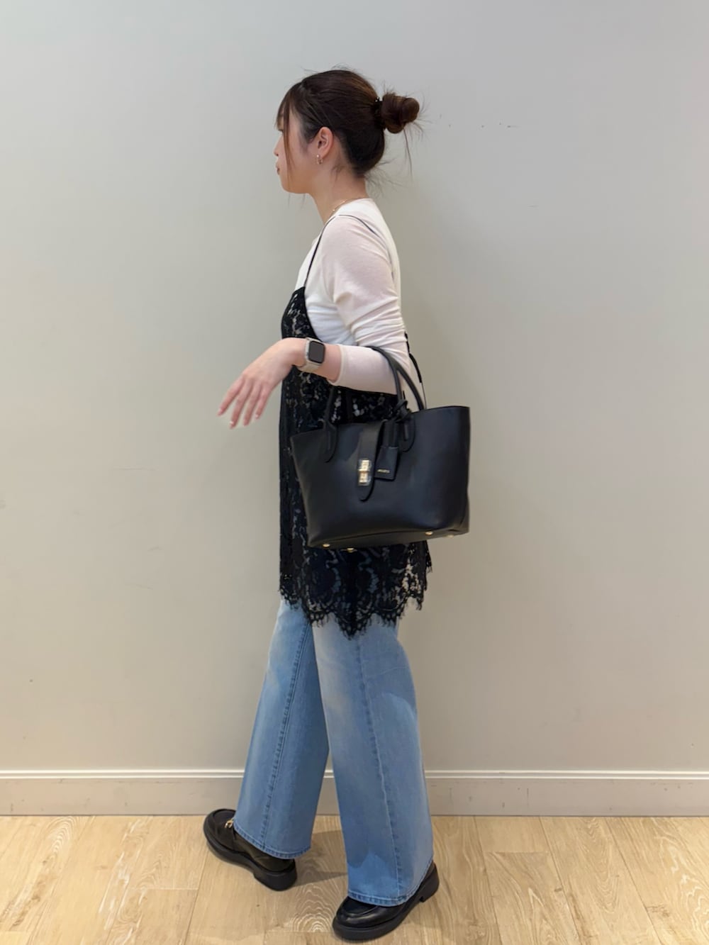 ブラック系のトートバッグ、ブルー系のデニムパンツ、ブラック系のキャミソールを着用したレディースの春コーディネートの2枚目の写真