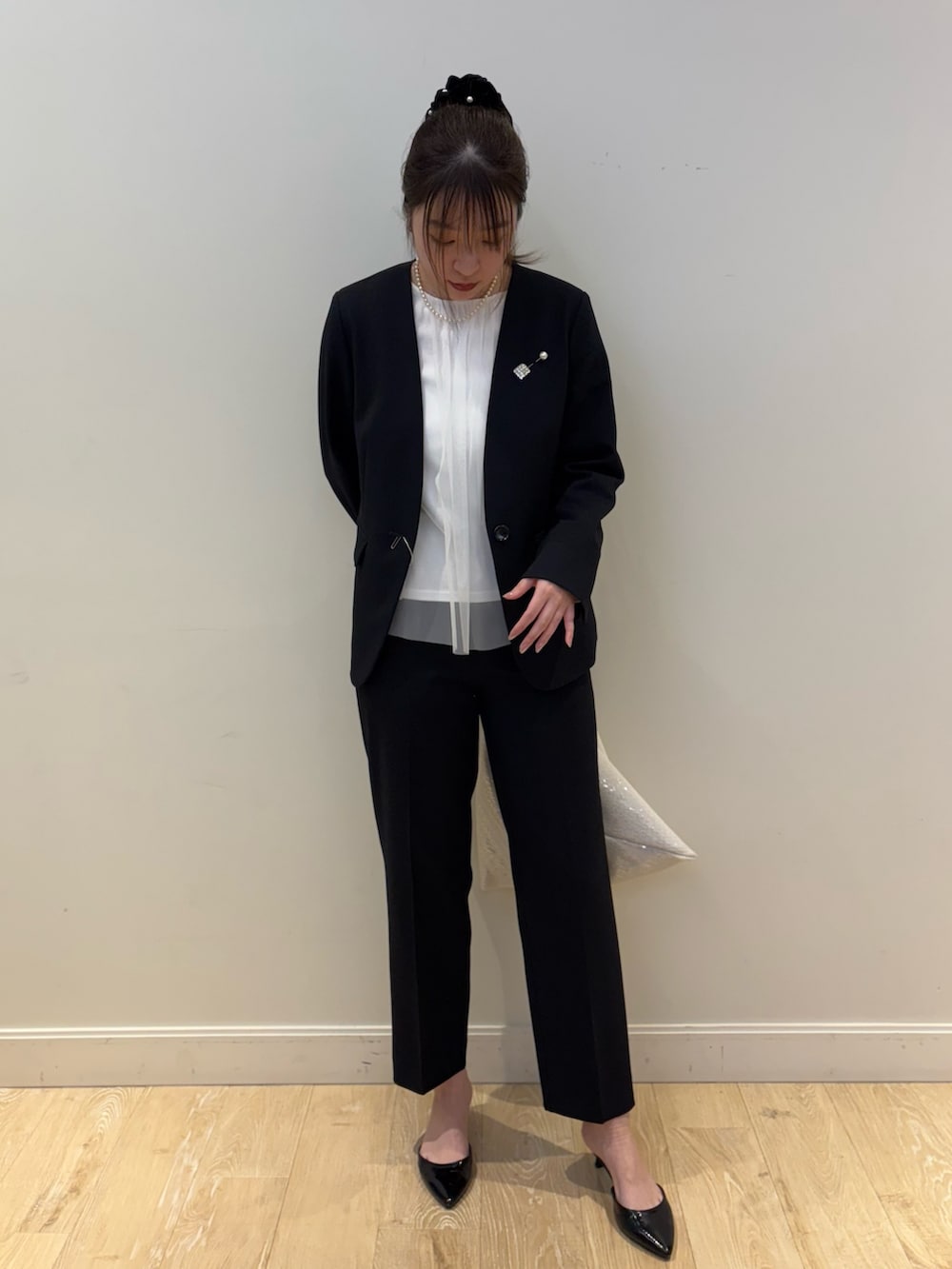 ホワイト系のショルダーバッグ、ホワイト系のシャツ/ブラウス、ブルー系のノーカラージャケットを着用したレディースの冬コーディネートの4枚目の写真