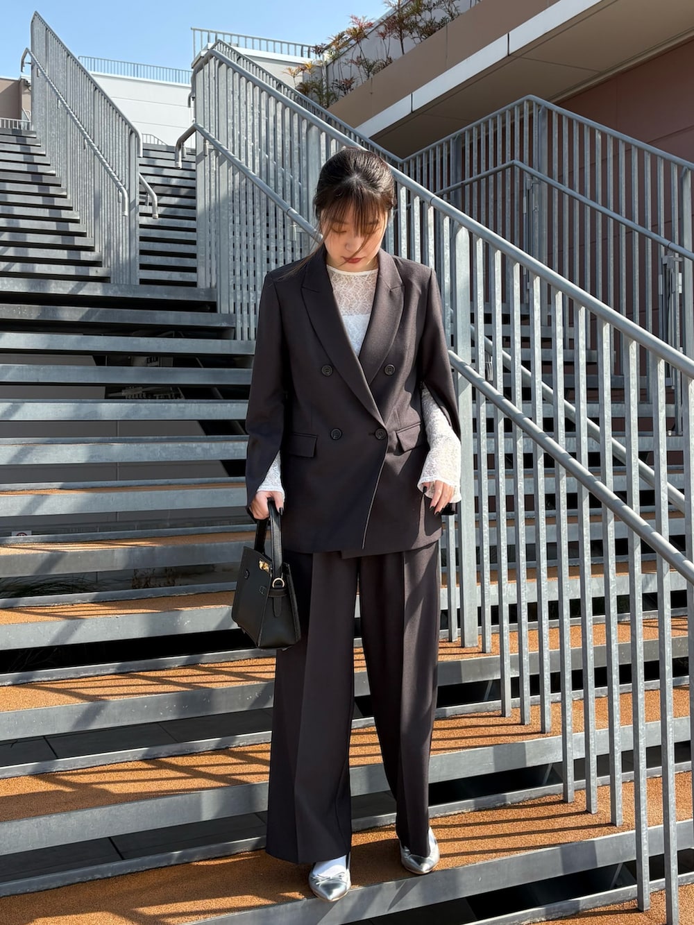 ブラック系のショルダーバッグ、ブラック系のTシャツ/カットソー、グレー系のテーラードジャケットを着用したレディースの冬コーディネートの4枚目の写真