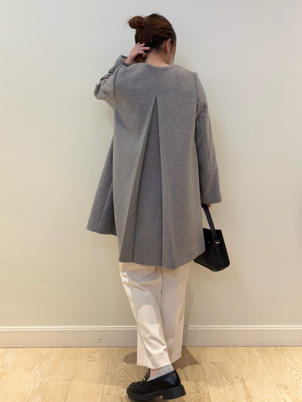 ブラック系のショルダーバッグ、ベージュ系のニット/セーター、ホワイト系のその他パンツを着用したレディースの冬コーディネートの2枚目の写真