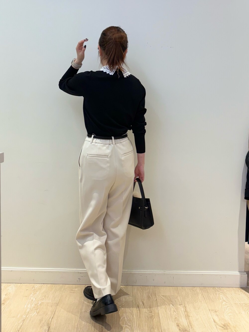 ブラック系のショルダーバッグ、ブラック系のニット/セーター、ホワイト系のその他パンツを着用したレディースの秋コーディネートの2枚目の写真