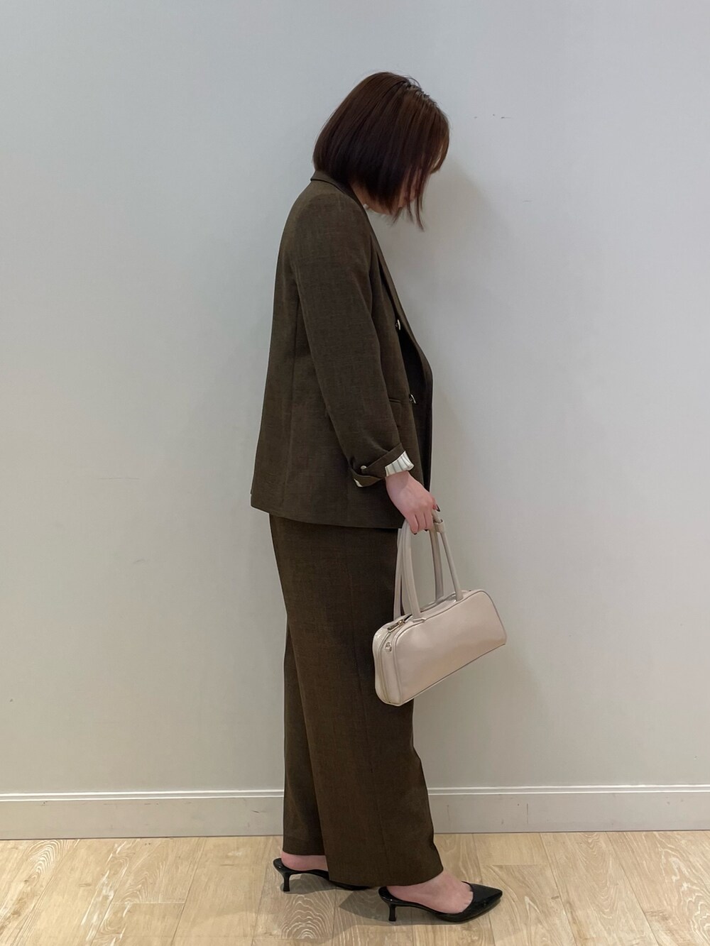 ブラウン系のテーラードジャケット、ブラウン系のその他パンツ、ホワイト系のシャツ/ブラウスを着用したレディースの夏コーディネートの3枚目の写真