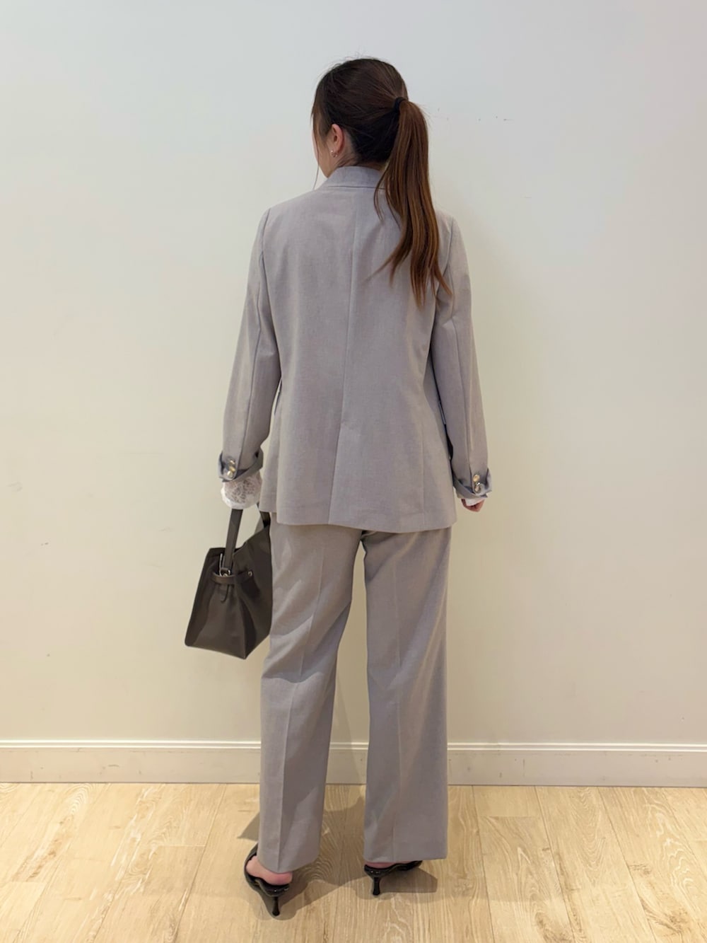 ベージュ系のトートバッグ、グレー系のテーラードジャケット、ブラック系のTシャツ/カットソーを着用したレディースの春コーディネートの2枚目の写真