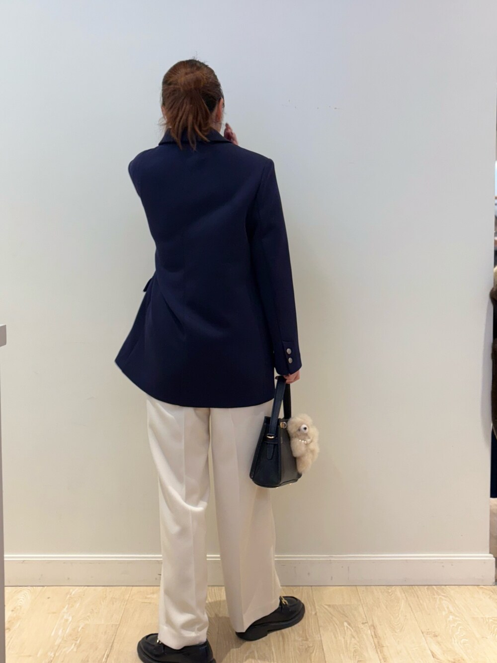 ブラック系のショルダーバッグ、ホワイト系のその他パンツ、ブラック系のニット/セーターを着用したレディースの秋コーディネートの2枚目の写真