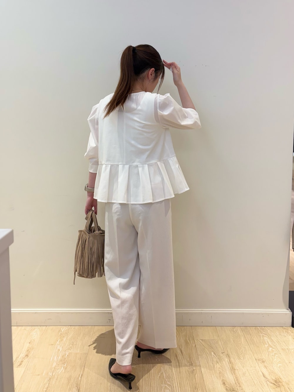 ホワイト系のタンクトップ、ホワイト系のシャツ/ブラウス、ベージュ系のショルダーバッグを着用したレディースの春コーディネートの2枚目の写真