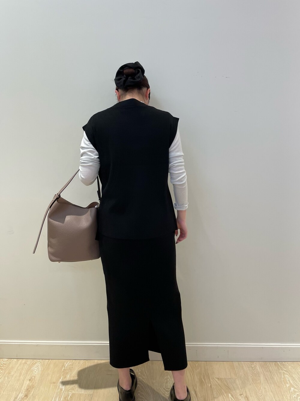 ブラック系のニット/セーター、ベージュ系のショルダーバッグ、シルバー系のTシャツ/カットソーを着用したレディースの冬コーディネートの4枚目の写真