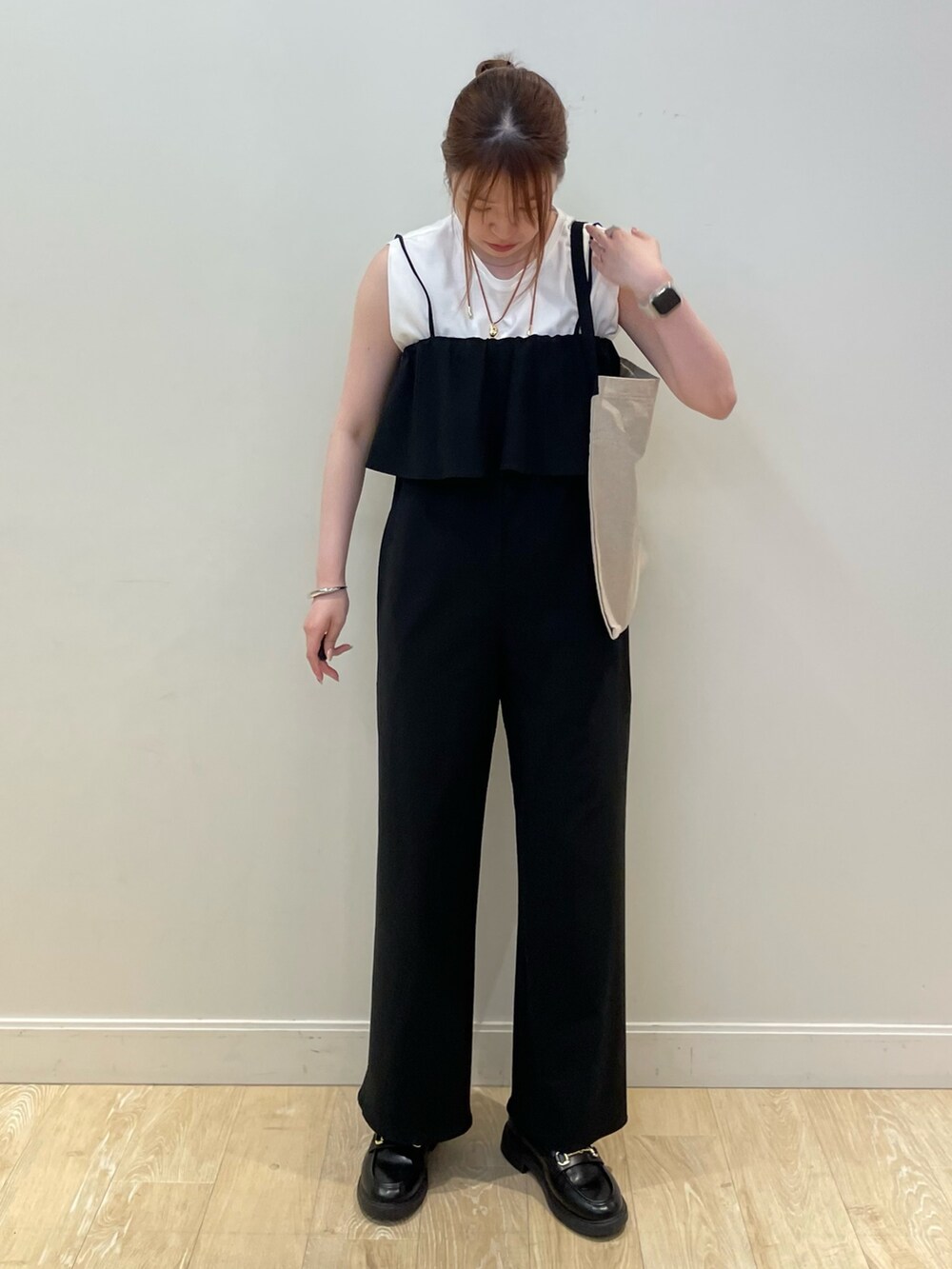 ブラック系のバックパック/リュック、ブラック系のサロペット/オーバーオール、ホワイト系のTシャツ/カットソーを着用したレディースの夏コーディネートの3枚目の写真