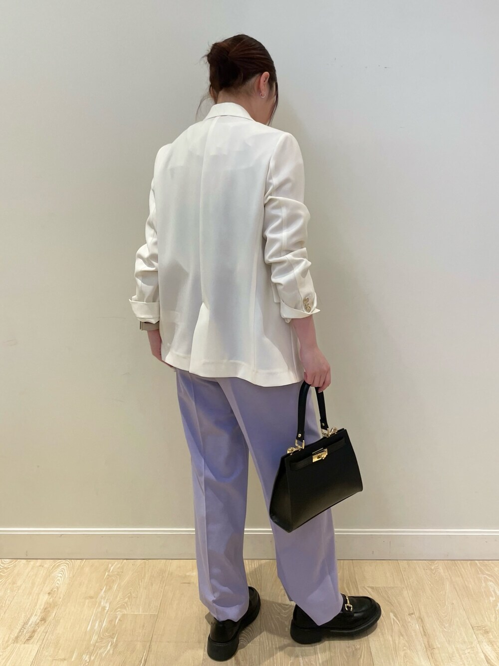 ブラック系のショルダーバッグ、ブルー系のシャツ/ブラウス、ホワイト系のテーラードジャケットを着用したレディースの春コーディネートの4枚目の写真
