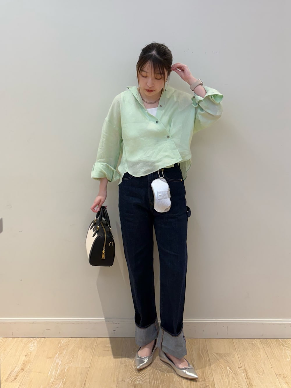 ホワイト系のタンクトップ、グリーン系のシャツ/ブラウス、ブラック系のボストンバッグを着用したレディースの春コーディネートの3枚目の写真