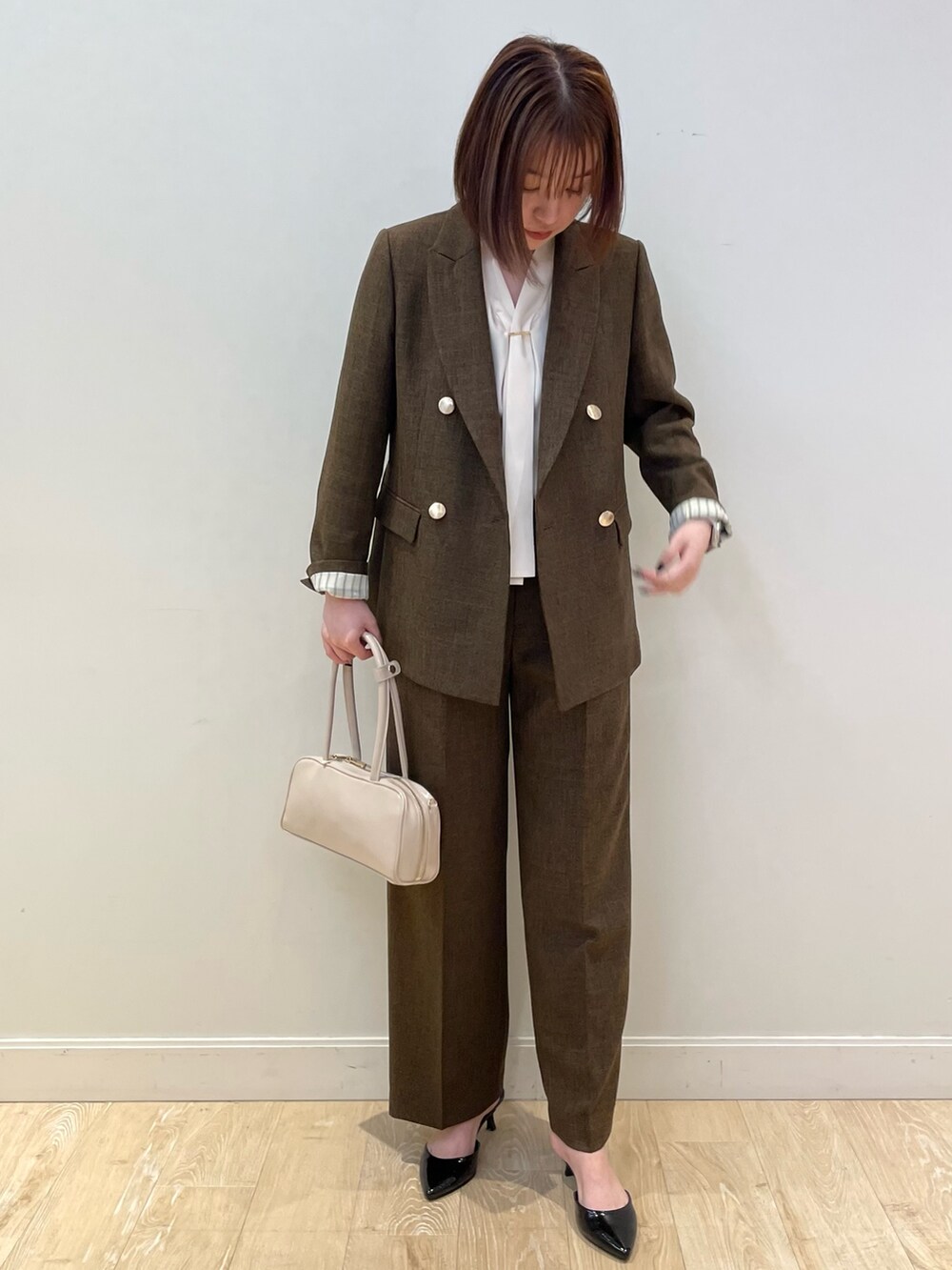 ブラウン系のテーラードジャケット、ブラウン系のその他パンツ、ホワイト系のシャツ/ブラウスを着用したレディースの夏コーディネートの5枚目の写真