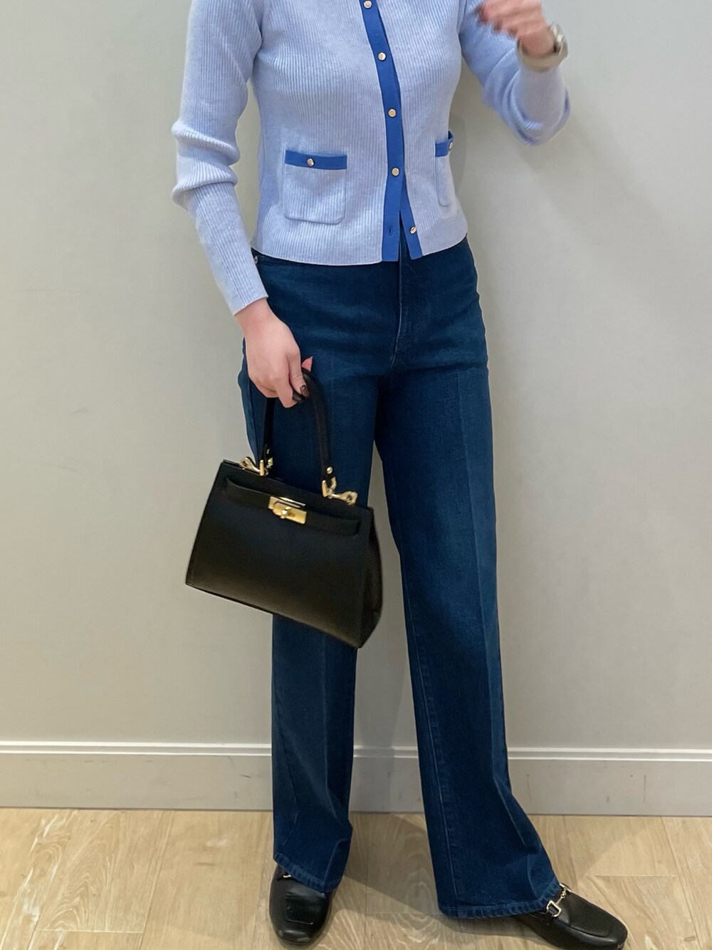 ブルー系のデニムパンツ、ブルー系のカーディガン/ボレロ、ブラック系のショルダーバッグを着用したレディースの冬コーディネートの4枚目の写真