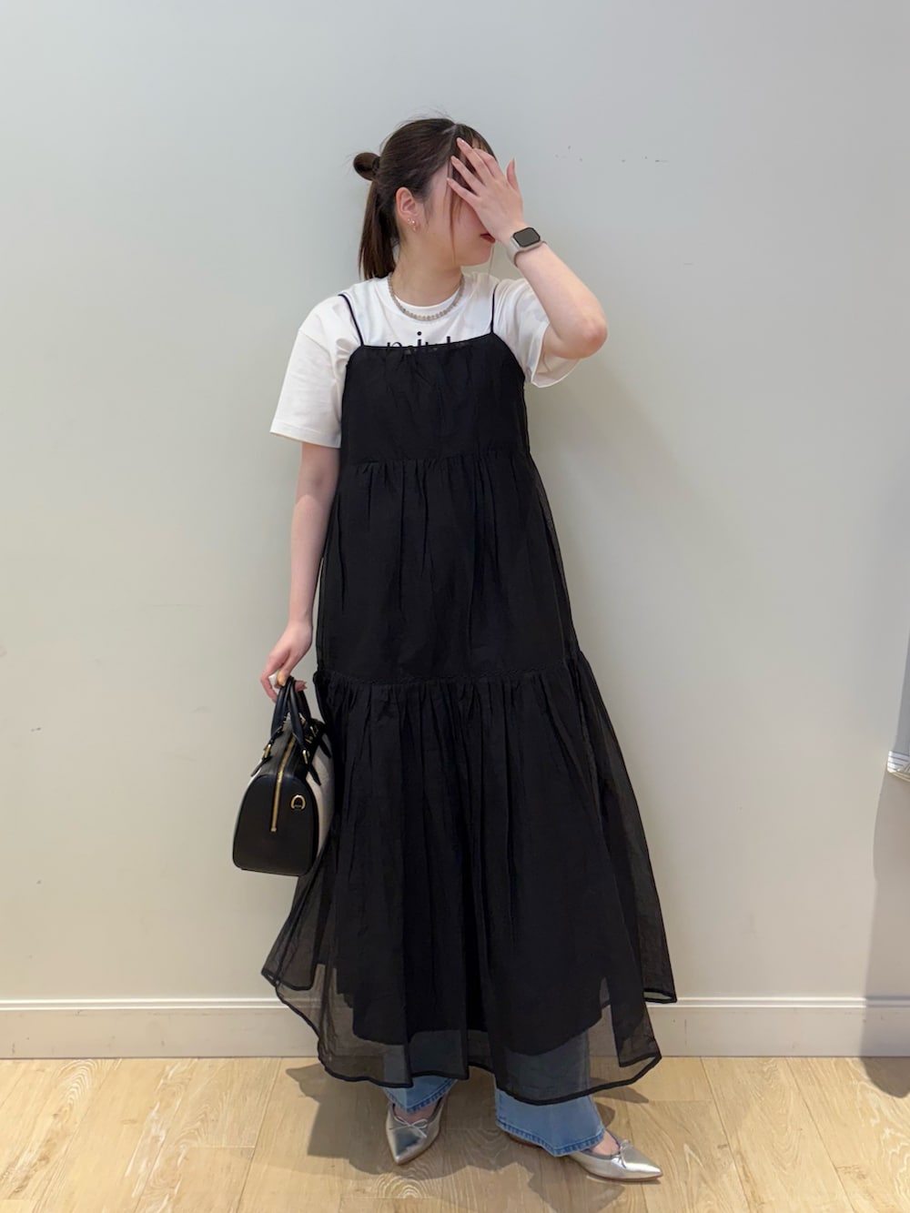 ブラック系のボストンバッグ、ホワイト系のTシャツ/カットソー、ブルー系のデニムパンツを着用したレディースの春コーディネートの3枚目の写真