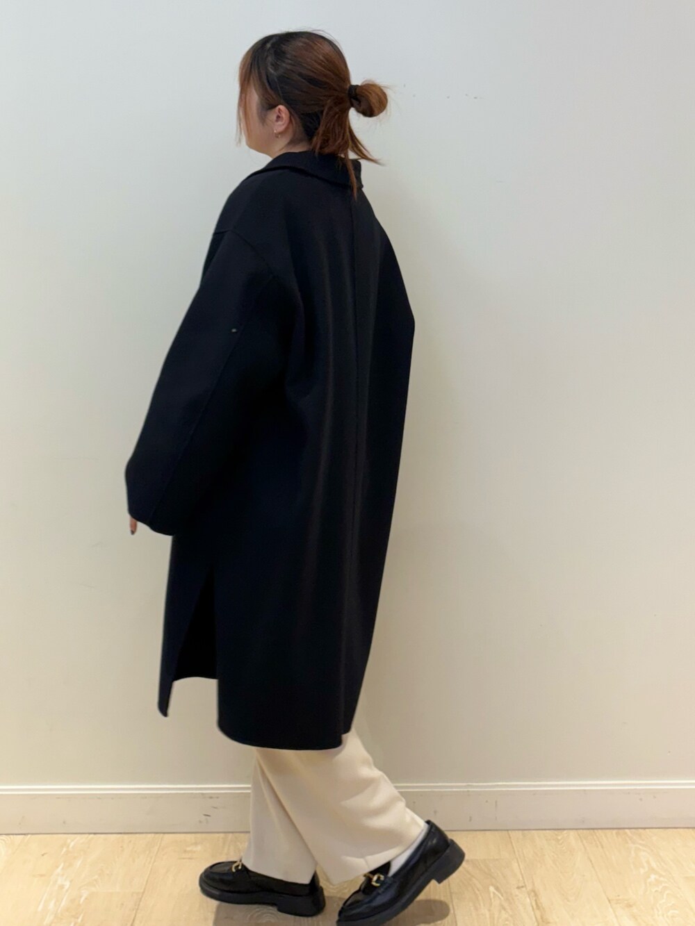 ブラック系のニット/セーター、ブラック系のショルダーバッグ、ホワイト系のその他パンツを着用したレディースの秋コーディネートの3枚目の写真