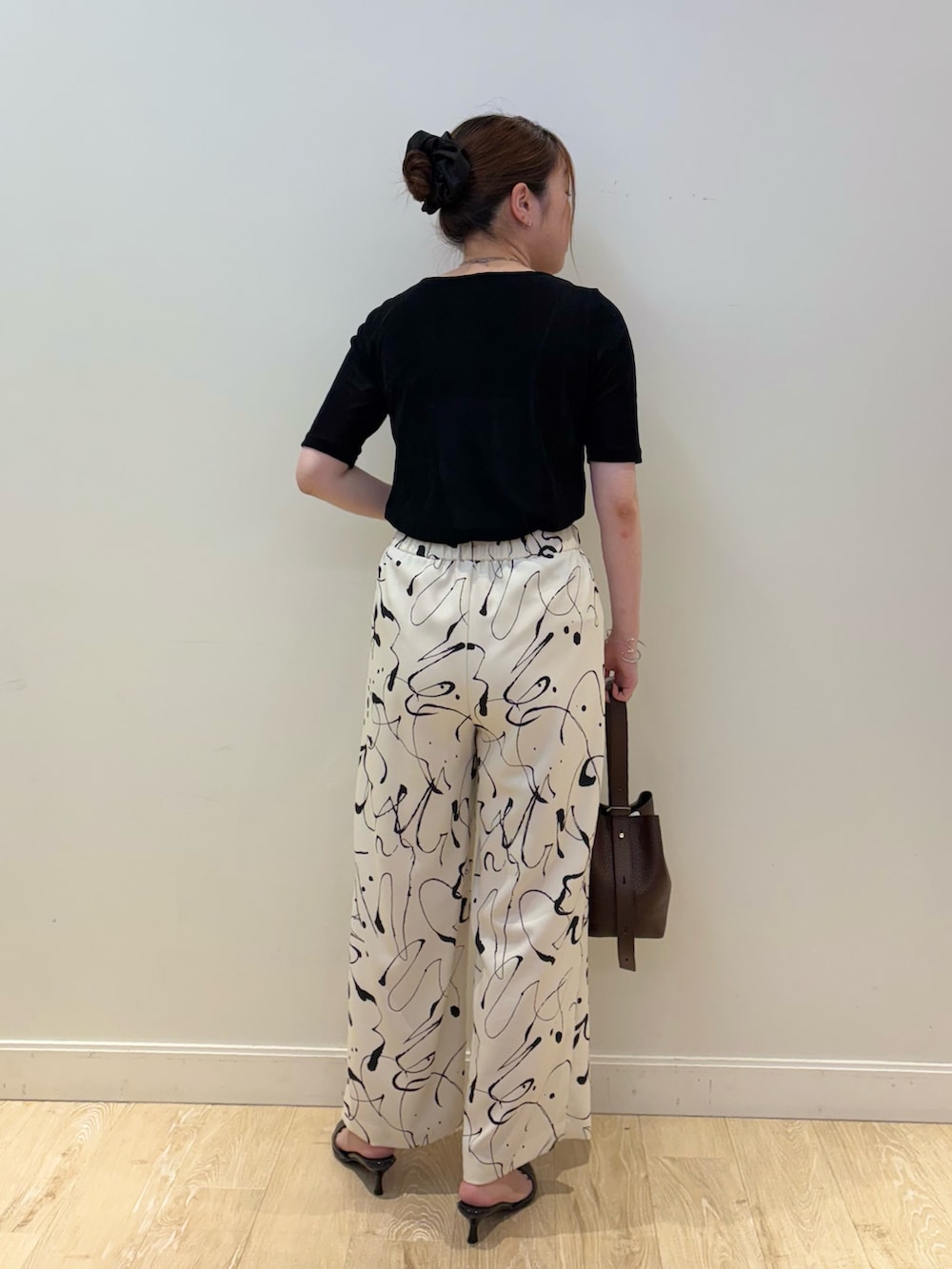 ブラウン系のショルダーバッグ、ホワイト系のその他パンツ、シルバー系のネックレスを着用したレディースの秋コーディネートの2枚目の写真