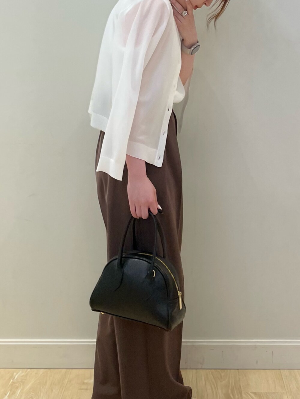 ブラック系のボストンバッグ、ホワイト系のタンクトップ、ブラウン系のその他パンツを着用したレディースの春コーディネートの4枚目の写真