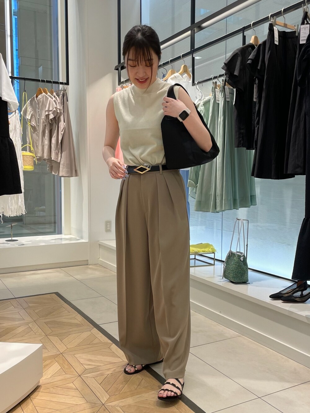 ゴールド系のニット/セーター、グリーン系のその他パンツ、ブラック系のショルダーバッグを着用したレディースの春コーディネートの6枚目の写真