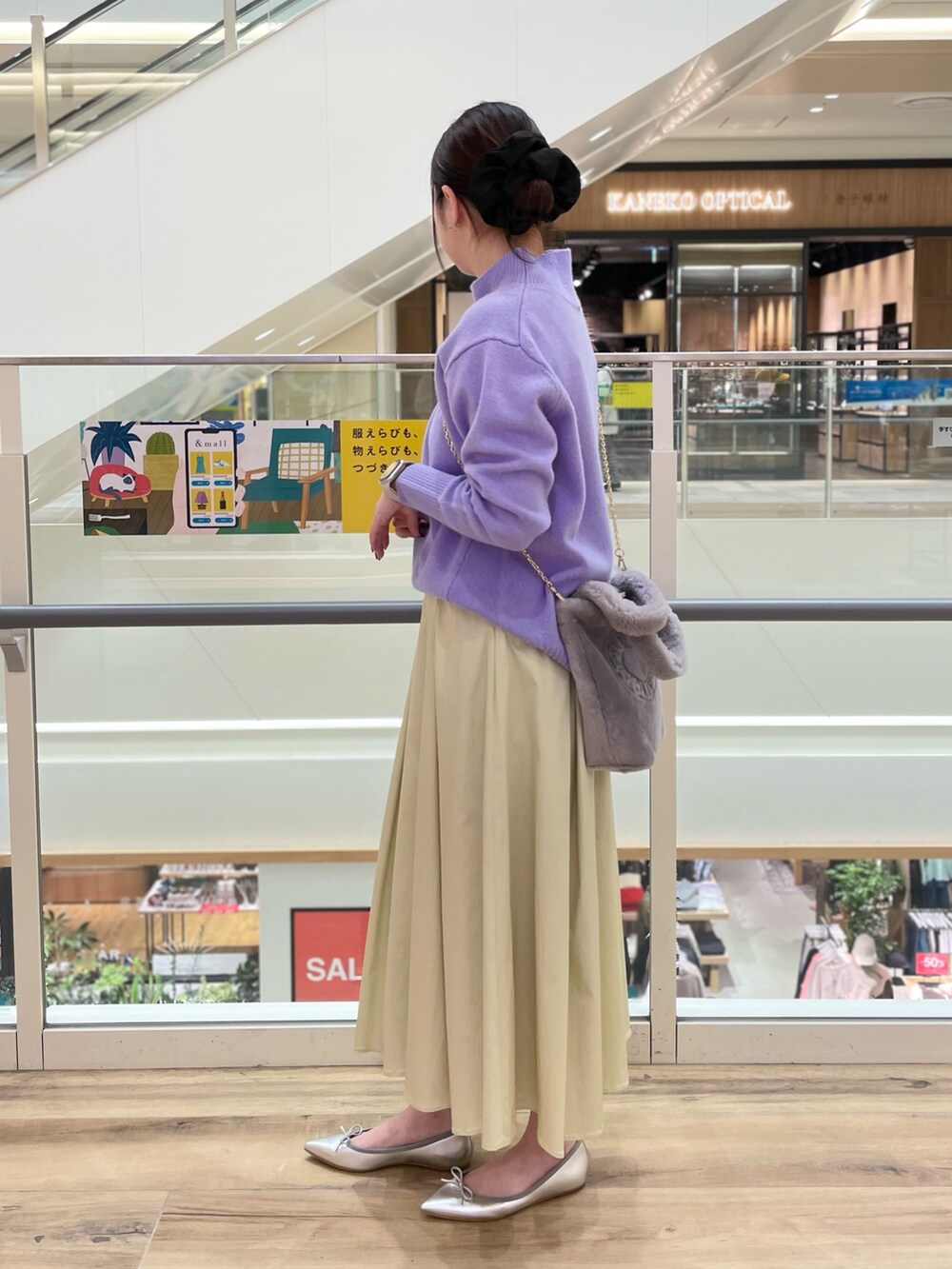 グレー系のトートバッグ、ホワイト系のニット/セーター、ベージュ系のスカートを着用したレディースの冬コーディネートの2枚目の写真