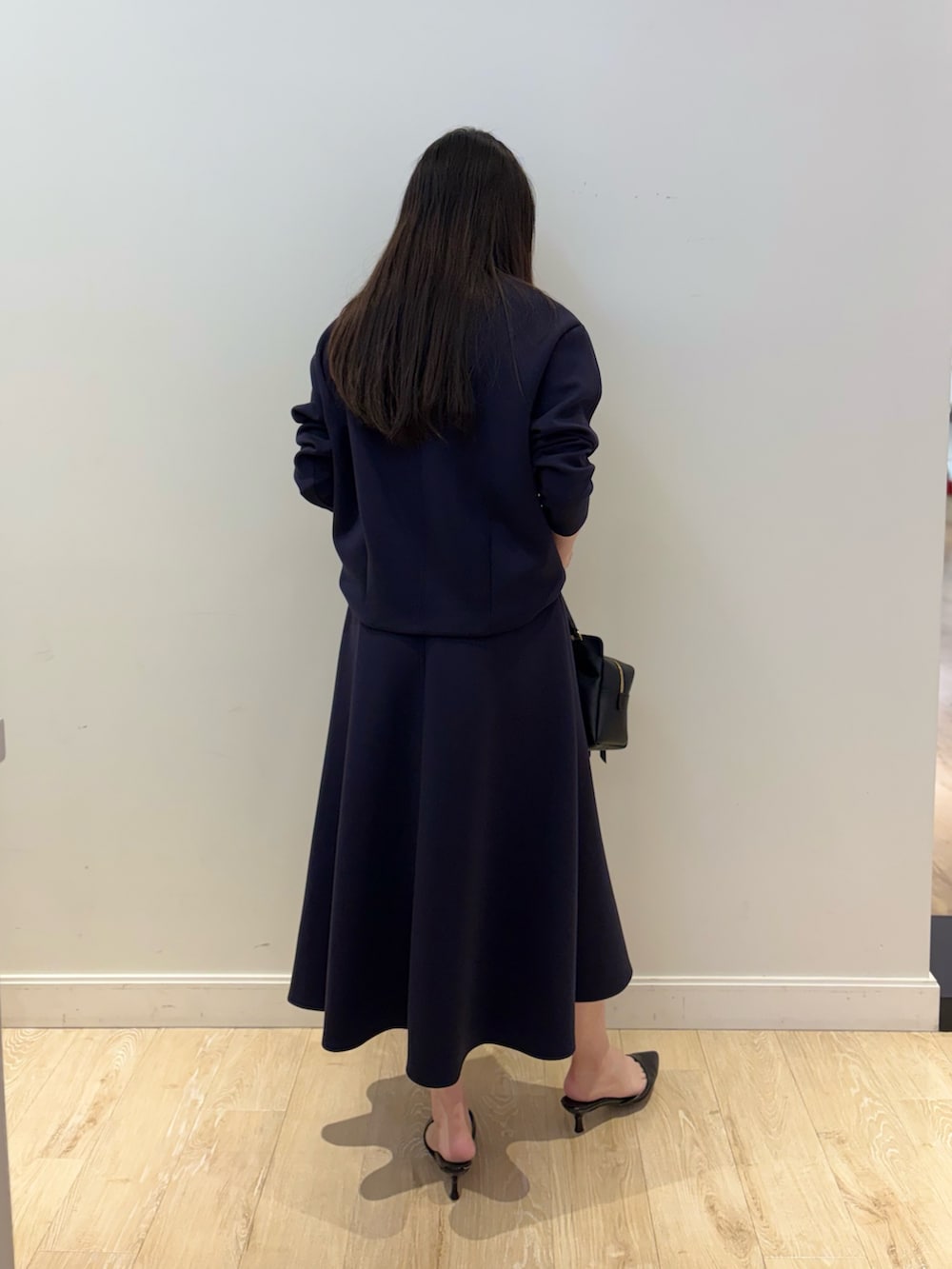 ブラック系のショルダーバッグ、ブルー系のTシャツ/カットソー、ブルー系のスカートを着用したレディースの秋コーディネートの4枚目の写真