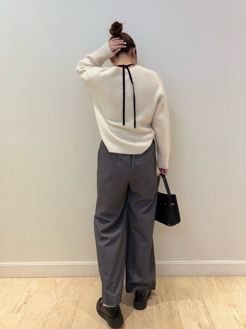 ブラック系のショルダーバッグ、ホワイト系のニット/セーター、グレー系のその他パンツを着用したレディースの秋コーディネートの2枚目の写真