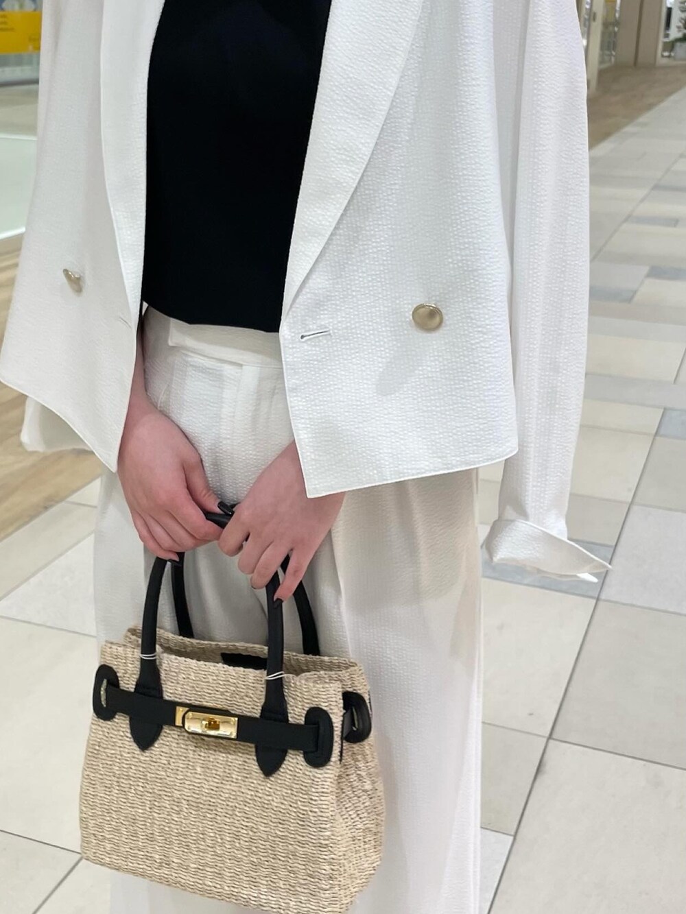 ホワイト系のその他パンツ、ブラック系のかごバッグ、ブラック系のパンプスを着用したレディースの夏コーディネートの5枚目の写真