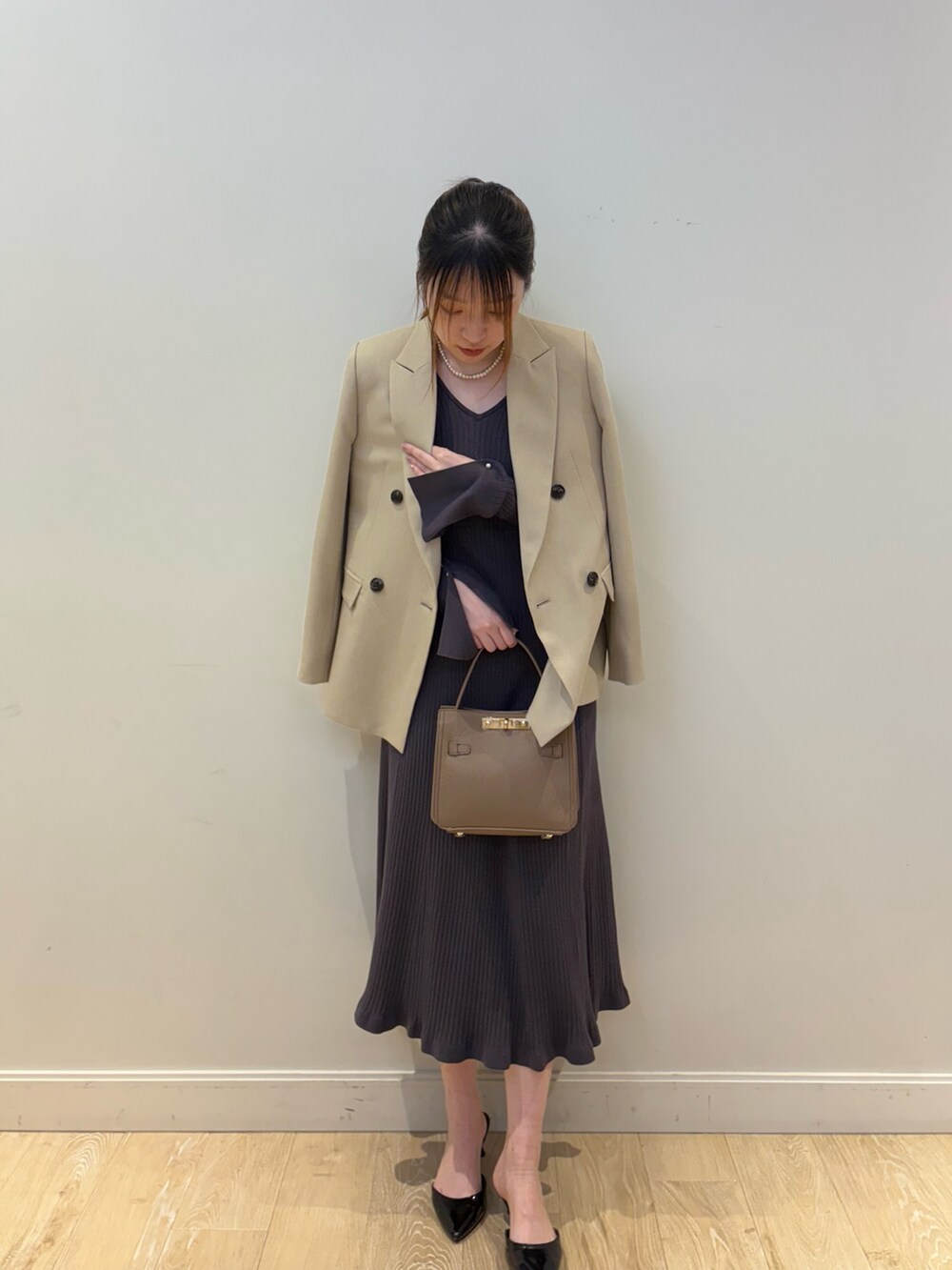ベージュ系のショルダーバッグ、グレー系のワンピース、ベージュ系のテーラードジャケットを着用したレディースの冬コーディネートの4枚目の写真