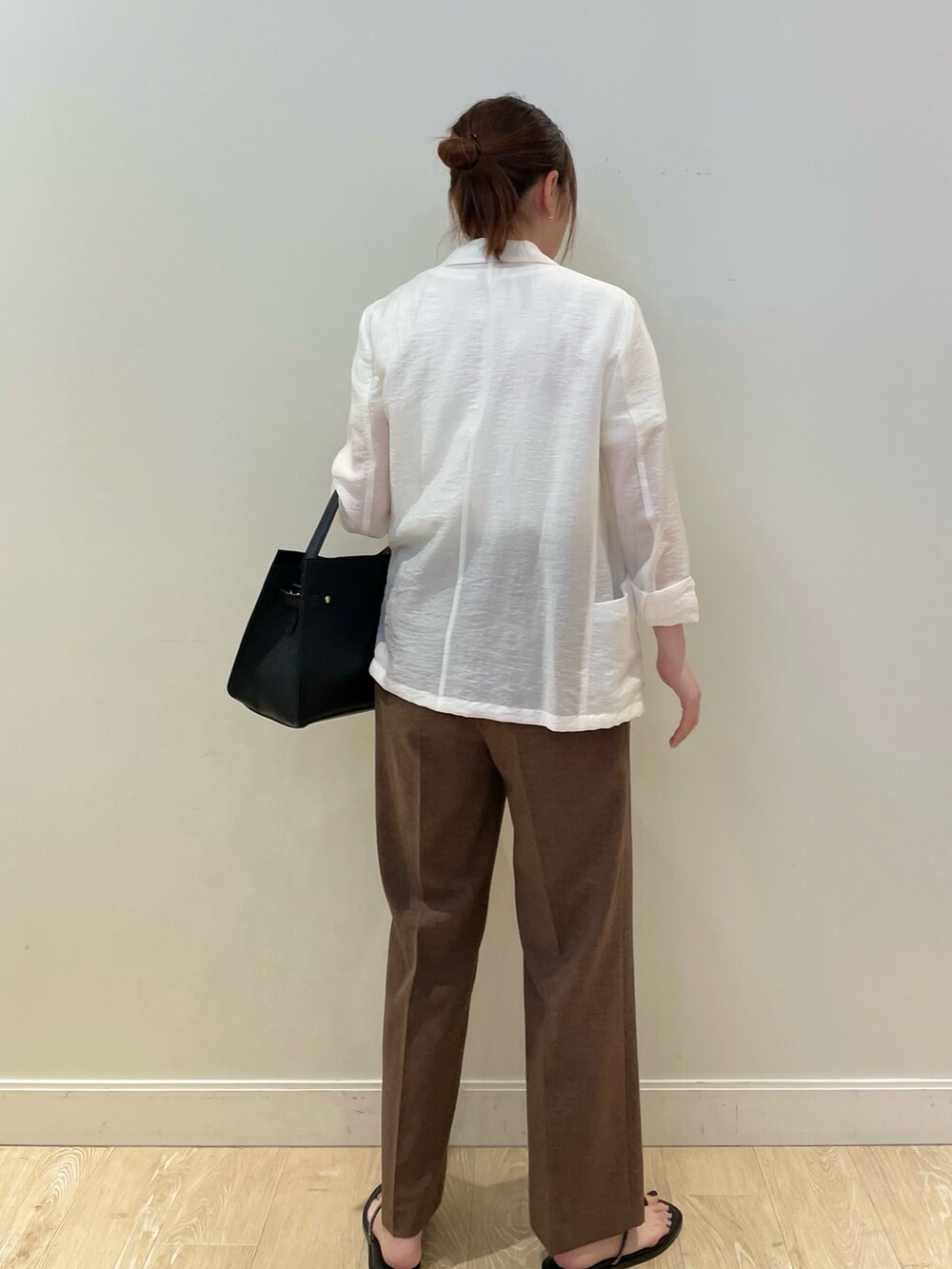 ブラック系のショルダーバッグ、グレー系のTシャツ/カットソー、ホワイト系のテーラードジャケットを着用したレディースの夏コーディネートの3枚目の写真