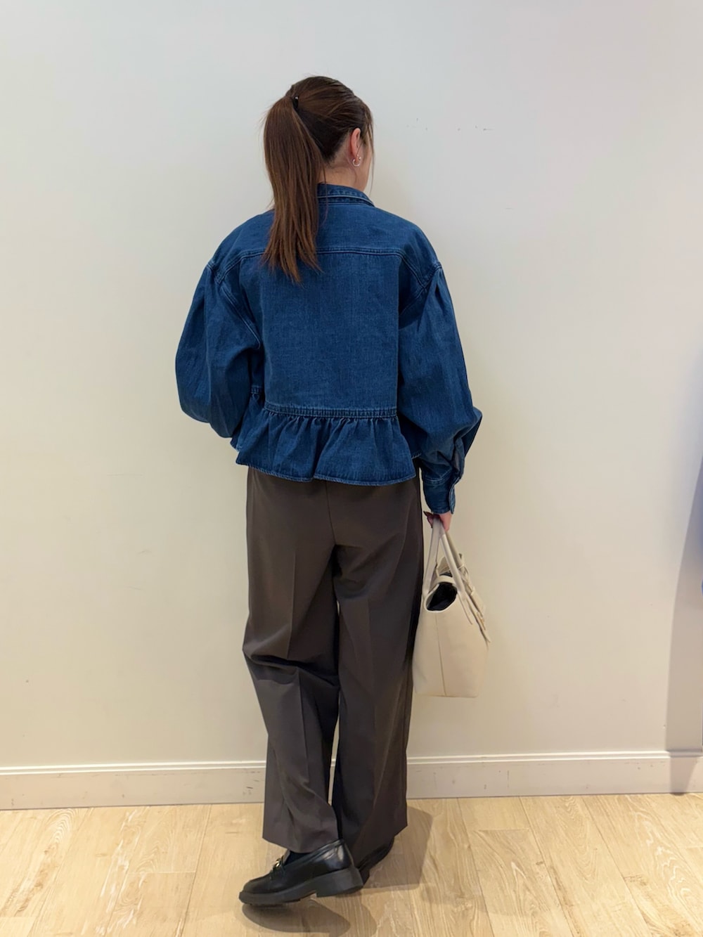 ブラック系のトートバッグ、ブルー系のブルゾン、グレー系のその他パンツを着用したレディースの冬コーディネートの2枚目の写真