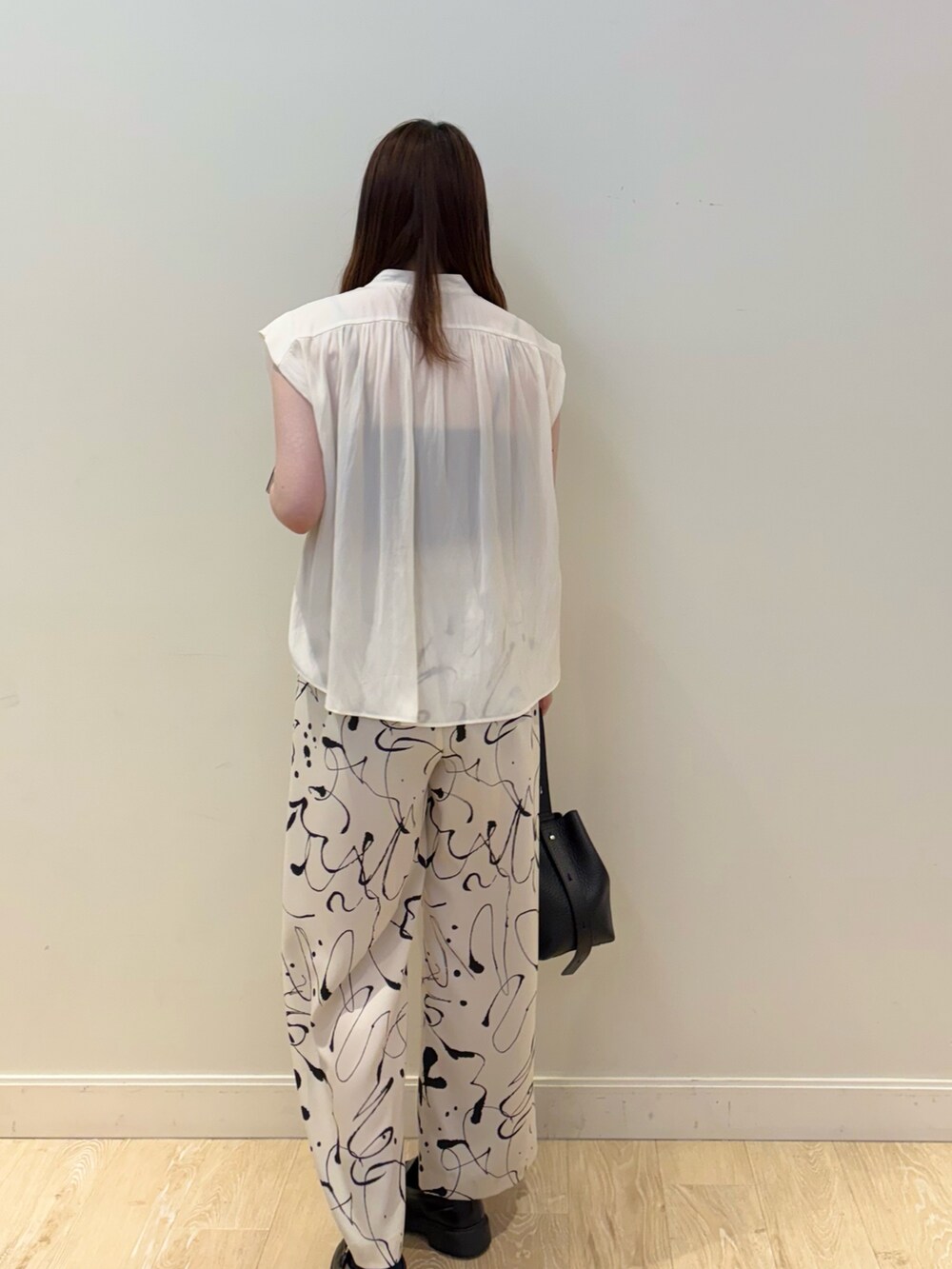 ブラウン系のショルダーバッグ、ホワイト系のその他パンツ、ホワイト系のシャツ/ブラウスを着用したレディースの夏コーディネートの2枚目の写真