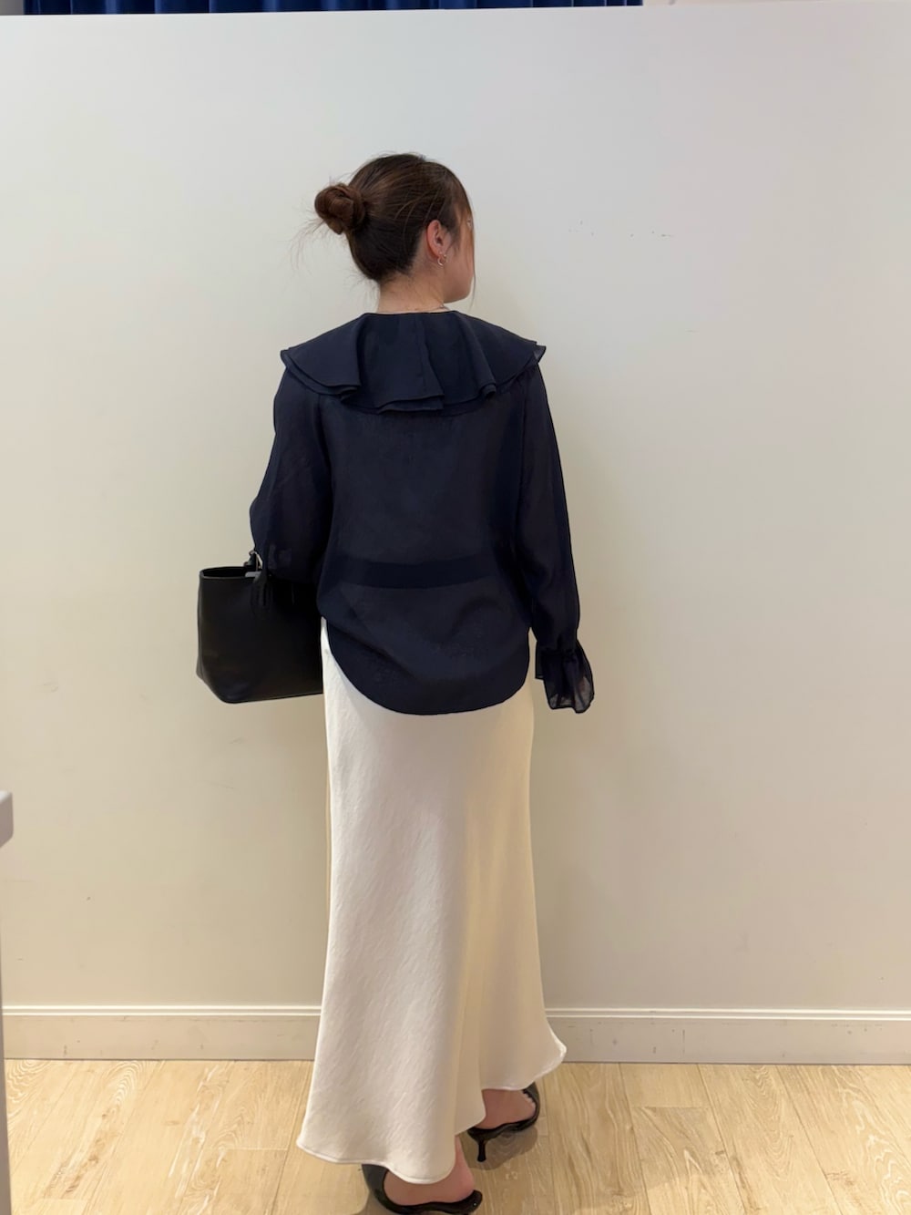 ブラック系のトートバッグ、ホワイト系のタンクトップ、ブルー系のシャツ/ブラウスを着用したレディースの春コーディネートの3枚目の写真