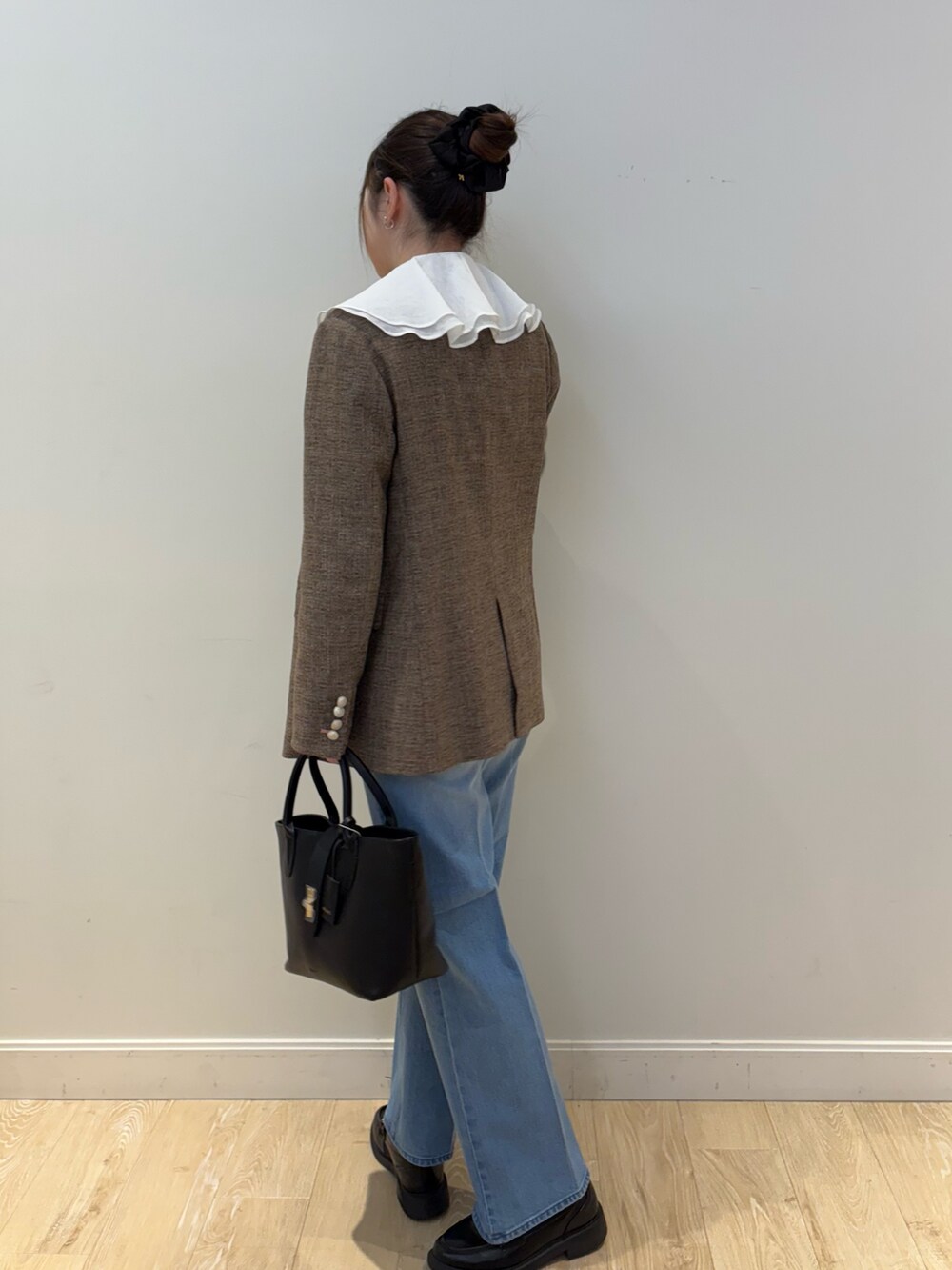 ブラック系のタンクトップ、ブルー系のテーラードジャケット、ブラック系のトートバッグを着用したレディースの冬コーディネートの3枚目の写真