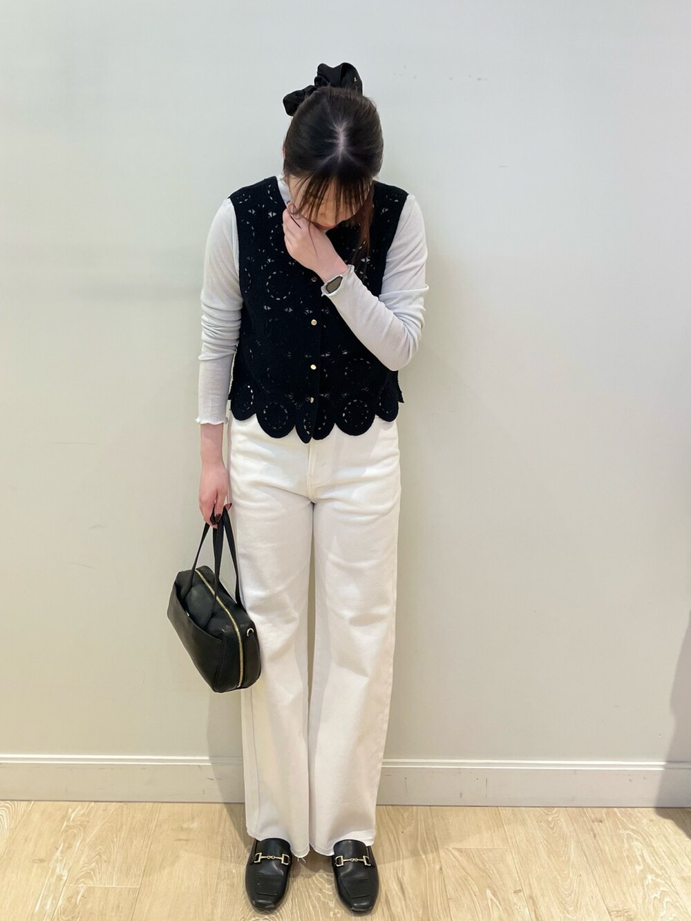 ホワイト系のデニムパンツ、ブラック系のベスト、シルバー系のTシャツ/カットソーを着用したレディースの冬コーディネートの5枚目の写真