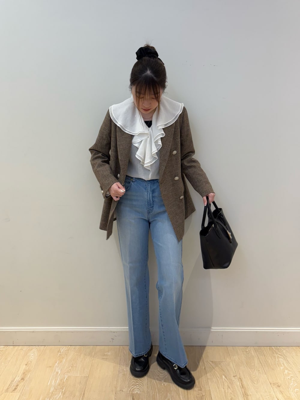 ブラック系のタンクトップ、ブルー系のテーラードジャケット、ブラック系のトートバッグを着用したレディースの冬コーディネートの4枚目の写真